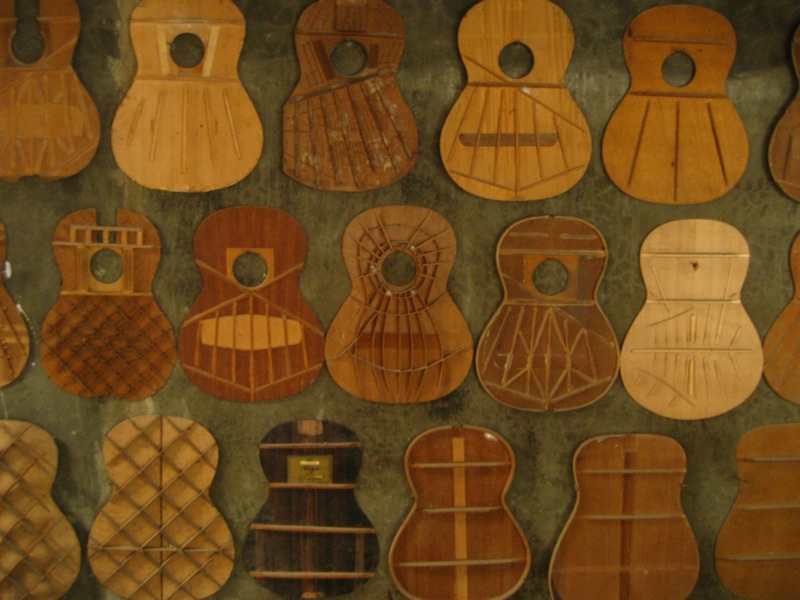 Wooden guitar soundboards display different internal bracing patterns at Alegre Guitar Factory.