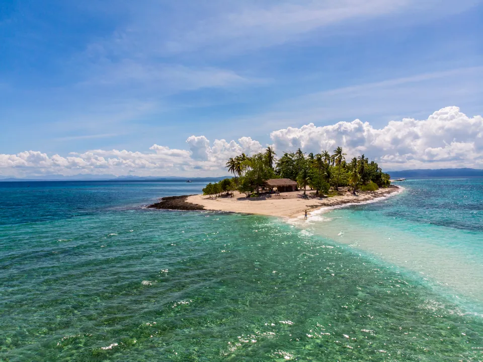 Kalanggaman Island's palm-lined shore and surrounding sea, photographed in 2024