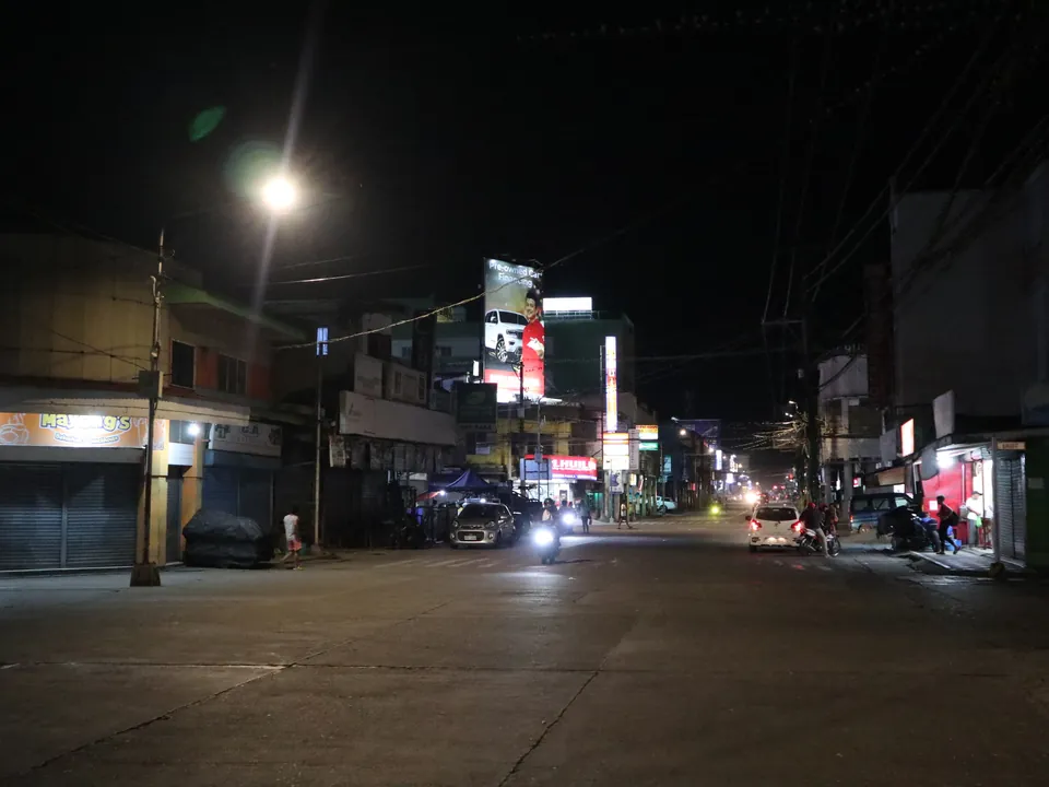 Shops and traffic in Ormoc's Aviles–Real street area at night in January 2024
